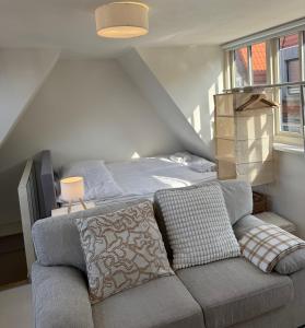 a bedroom with a bed and a couch in front of it at tiny beach house noordwijk in Noordwijk aan Zee
