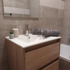 a bathroom with a white sink and a tub at Árnyas Part Vendégház in Gyomaendrőd +81 photos