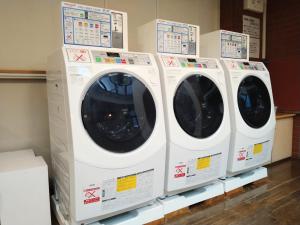 four white washing machines on display in a store at Morioka New City Hotel in Morioka