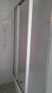 a shower with a glass door in a bathroom at Atlantis Appartement in Egmond aan Zee