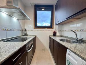 a kitchen with a sink and a window at Apto Holibai Nidiño, Apartamento cerca de la playa, Acepta mascotas, in Baiona +9 photos
