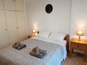 a bedroom with a bed with two towels on it at Four Reasons Apts Kamena Vourla in Kamena Vourla +48 photos