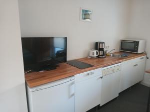 a kitchen with a counter with a television and a microwave at CityZimmer Eltmann in Eltmann