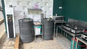 a kitchen with three trash cans and a microwave at Woodstock Camp Chalet in Bentong +16 photos