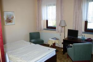 ein Hotelzimmer mit einem Bett, einem Schreibtisch und Stühlen in der Unterkunft Landhotel Goldener Löwe mit Pension Am Taurastein in Burgstaedt
