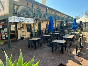 a group of tables and chairs with blue umbrellas at Settlers House York in York