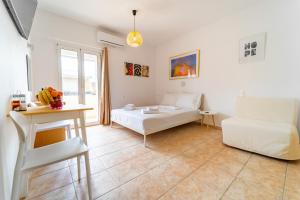 a white living room with a bed and a table at Beachfront Cozy Apartments in Amoudara Herakliou