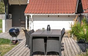 a table and chairs on a deck with a grill at Three-Bedroom Holiday Home In Thisted in Nørre Vorupør +10 photos