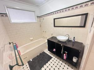 a bathroom with a sink and a bath tub and a sink at Comfortable and Spacious Queen Room - SW2 in Wentworthville