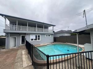 a house with a swimming pool in front of a house at Comfortable and Spacious Queen Room - SW2 in Wentworthville +6 photos