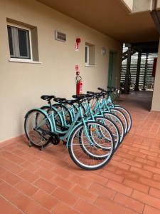 a row of blue bikes parked next to a wall at Residence San Francesco in Tirrenia