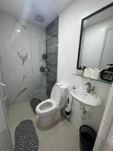 a bathroom with a toilet and a sink and a shower at D&D Transient House in Sampong