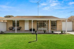 a house with a green lawn in front of it at Barwon Heads Hotel in Barwon Heads