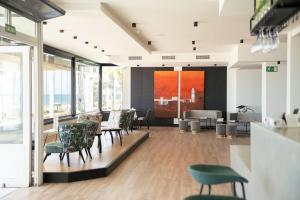 a dining room with chairs and tables and windows at FAY Victoria Beach in Rincón de la Victoria