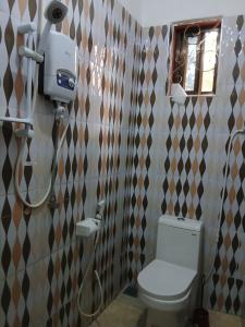 a bathroom with a toilet and a shower in it at 2M Tarangire Lodge in Kwa Kuchinia