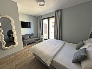 a bedroom with a bed and a mirror and a couch at Motel Living Walldürn in Walldürn