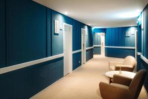 a hallway with blue walls and chairs and a table at Velamar Boutique Hotel - Adults Friendly in Albufeira