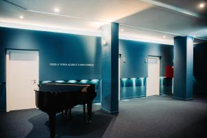 a room with a piano and a blue wall at Velamar Boutique Hotel - Adults Friendly in Albufeira