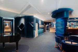 a room with blue walls and a piano and chairs at Velamar Boutique Hotel - Adults Friendly in Albufeira