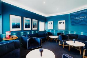 a waiting room with blue chairs and tables at Velamar Boutique Hotel - Adults Friendly in Albufeira