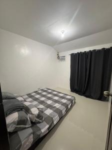 a bedroom with a bed with a checkered blanket at D&D Transient House in Sampong +15 photos