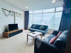 a living room with a blue couch and a tv at Vortex Suites Klcc 2bedroom & 3bedroom apartment in Kuala Lumpur
