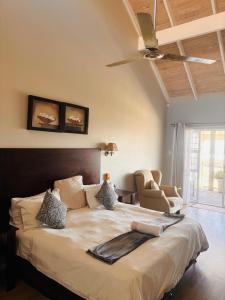 a bedroom with a large bed with a ceiling fan at Sir Roys Guesthouse At The Sea in Port Elizabeth