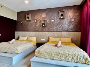 two beds sitting next to each other in a bedroom at Serene Trefoil Home - Walk to Setia City Mall & Setia City Convention Centre in Shah Alam +32 photos