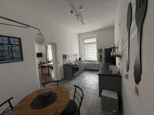 a kitchen and dining room with a table and a kitchen with a counter at Ferienwohnung Gubener Neißeglück 23 in Guben