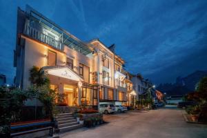 张家界Flower Whisperer Homestay Tianmenshan Store free airport and station pick-up的一栋大楼前停着一辆汽车