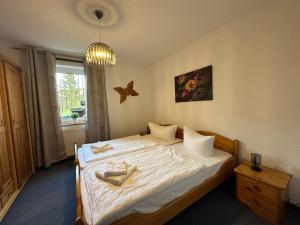 HagenにあるLandferienhaus Sonnenblumeの白いシーツと窓のあるベッドのある寝室