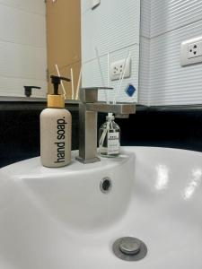 a bathroom sink with a bottle of soap on it at Modern and Slick Condo in Venice near Makati and BGC in Sampong +23 photos