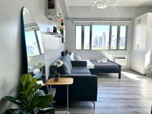a living room with a couch and a bed at Modern and Slick Condo in Venice near Makati and BGC in Sampong