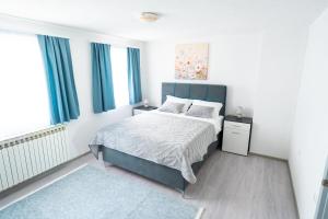 a bedroom with a bed with a blue headboard at Apartman 11 in Tomislavgrad