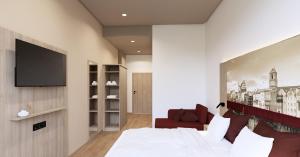a bedroom with a bed and a flat screen tv at Das Wasserburg Hotel in Wasserburg am Inn