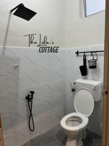 a bathroom with a toilet and a sign that says ice lifes coffee at The LuLas Cottage in Malacca +8 photos
