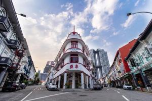 a large white building on a city street at A Hotel Chinatown in Singapore