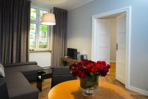 a living room with a vase of red roses on a table at apartament PAULOVE in Krakow