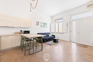 Una cocina con una mesa y sillas en una habitación. en La casa di Amelie, en Cabras