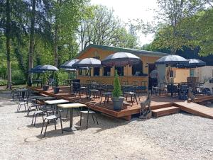 a group of tables and chairs with umbrellas at EVASION LOUE #6 x2 people "La BRIQUERIE" in Lods