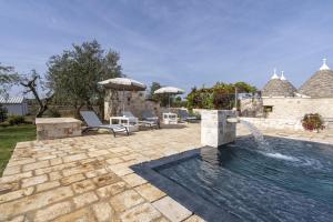 - une piscine avec une fontaine dans la cour dans l'établissement Trulli Orma, à Martina Franca