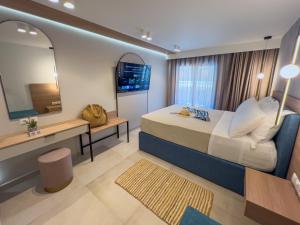 a bedroom with a bed and a desk and a mirror at Luxury Rooms Naoum - Adults only in Limenaria