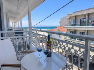 a table with two glasses of wine on a balcony at Luxury Rooms Naoum - Adults only in Limenaria