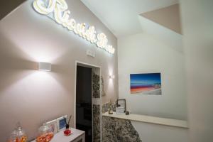 a bathroom with a sign on the wall at B&B Riccioli D'oro in Margherita di Savoia +53 photos