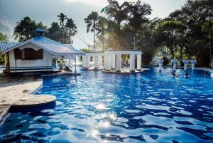 奇旺Riverside Springs Resort的蓝色海水游泳池和凉亭