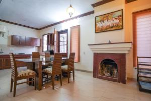 a dining room with a table and a fireplace at Casa Belvedere Luxury Villas in Dagshai