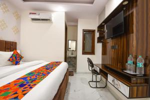 um quarto de hotel com uma cama e uma TV de tela plana em FabHotel NP International - Nehru Place Market em Jāmb