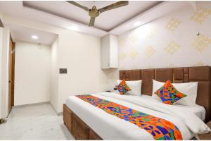 um quarto com uma cama grande com almofadas coloridas em FabHotel NP International - Nehru Place Market em Jāmb