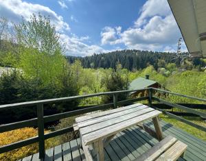 a wooden bench sitting on top of a deck at Domki przy lesie 300m od jeziora 509-619-803 in Zawóz