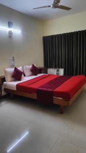 ein Schlafzimmer mit einem großen Bett mit roten und weißen Kissen in der Unterkunft Madras Heights in Chennai